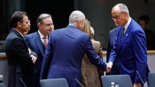 French President Emmanuel Macron, center, speaks with European Commission President Ursula von der Leyen during a round table meeting at the EU summit in Brussels, 15 October.