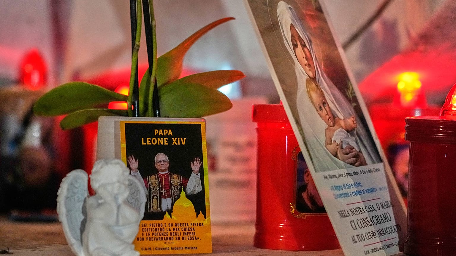 Una imagen del papa León XIV descansa a los pies de una estatua del difunto papa Juan Pablo II frente al Policlínico Agostino Gemelli, en Roma, el 13 de octubre de 2026.