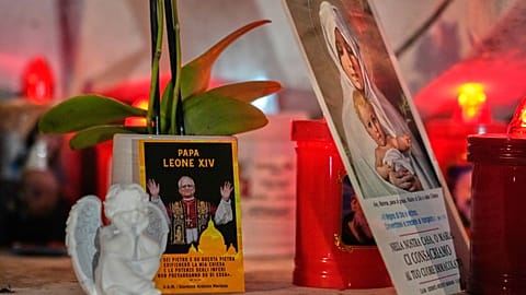 An image of Pope Leo XIV rests at the foot of a statue of the late Pope John Paul II outside the Agostino Gemelli Polyclinic in Rome on 13 October 2026.