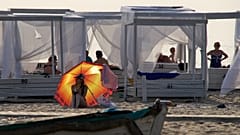 Παραθεριστής κάθεται κάτω από ομπρέλα στην ακτή στη Γιαντάρνι, θέρετρο στη χερσόνησο Σαμπίας, στη δυτική ρωσική περιοχή Καλίνινγκραντ, 5 Αυγούστου 2026