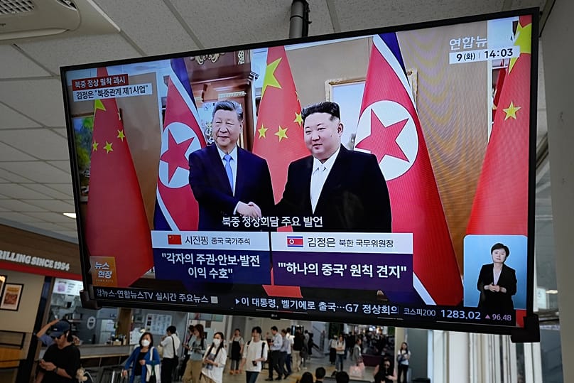 A TV screen shows an image of Chinese President Xi Jinping and North Korean leader Kim Jong Un at a bus terminal in Seoul, 9 June, 2026