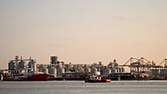 A barge sails backdropped by a damaged warehouse following the self detonation of a maritime drone in the Black Sea port of Constanta, 5 June, 2026