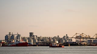A barge sails backdropped by a damaged warehouse following the self detonation of a maritime drone in the Black Sea port of Constanta, 5 June, 2026