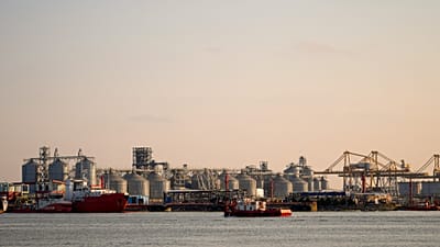 A barge sails backdropped by a damaged warehouse following the self detonation of a maritime drone in the Black Sea port of Constanta, 5 June, 2026