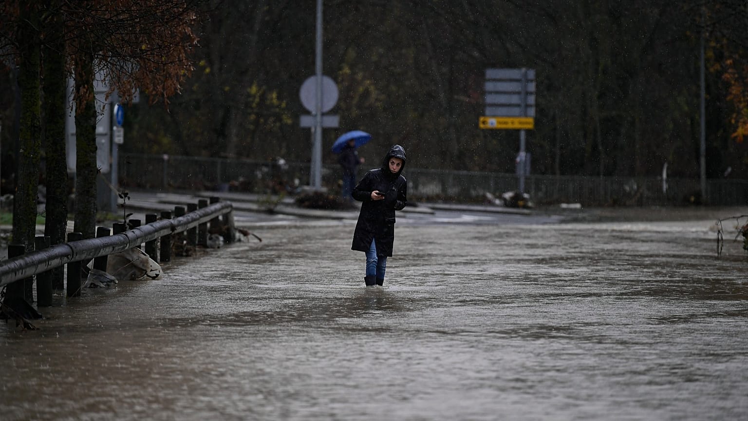 Una mujer camina por una zona inundada en el municipio de Huarte, cerca de Pamplona, ​​España, el 10 de diciembre de 2021. (Foto AP/Alvaro Barrientos)