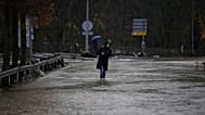 Una mujer camina por una zona inundada en el municipio de Huarte, cerca de Pamplona, ​​España, el 10 de diciembre de 2021. (Foto AP/Alvaro Barrientos)