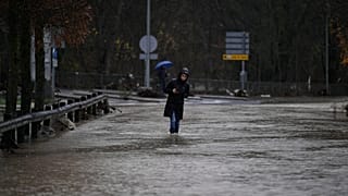 Una mujer camina por una zona inundada en el municipio de Huarte, cerca de Pamplona, ​​España, el 10 de diciembre de 2021. (Foto AP/Alvaro Barrientos)