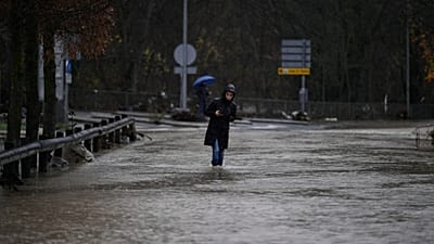 Una mujer camina por una zona inundada en el municipio de Huarte, cerca de Pamplona, ​​España, el 10 de diciembre de 2021. (Foto AP/Alvaro Barrientos)