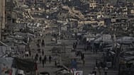 فلسطينيون يسيرون على طول شارع تصطف على جانبيه المباني التي دمرت خلال الحرب بين إسرائيل وحماس في مدينة غزة الأربعاء 14 أكتوبر 2026.