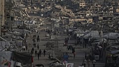 فلسطينيون يسيرون على طول شارع تصطف على جانبيه المباني التي دمرت خلال الحرب بين إسرائيل وحماس في مدينة غزة الأربعاء 14 أكتوبر 2026.