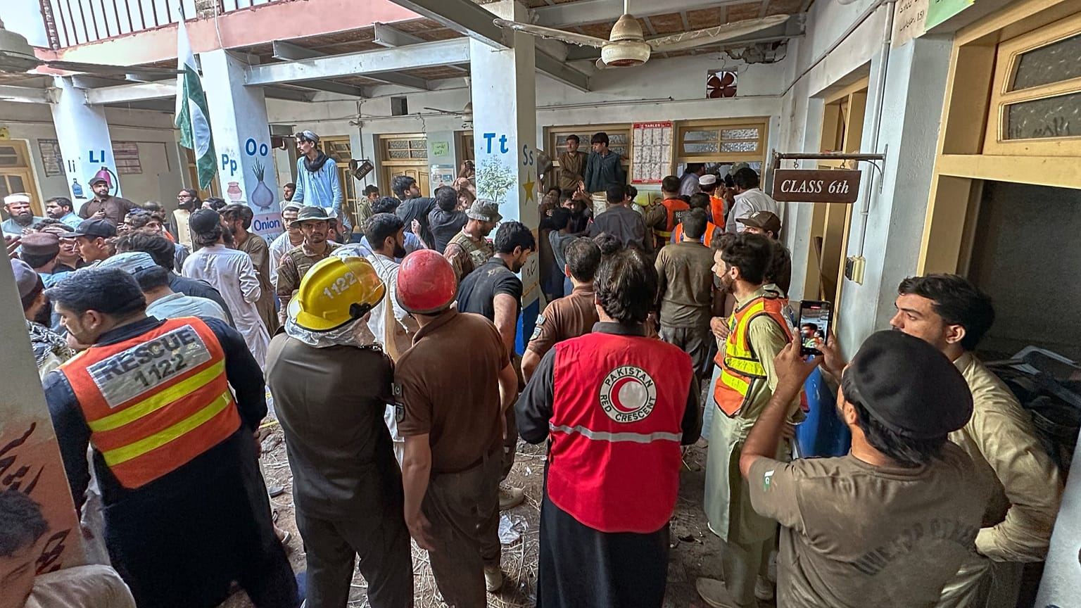 Rescue workers and volunteers take part in the rescue operation at the site of a roof collapse at a private school in Peshawar, 15 October, 2026
