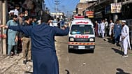 A volunteer clears the way for an ambulance transporting injured school children following a roof collapse at a private school in Peshawar, 15 October, 2026