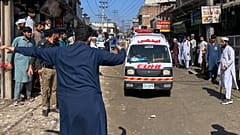 Un voluntario despeja el paso a una ambulancia que transporta a escolares heridos tras el derrumbe del techo de un colegio privado en Peshawar, 15 de octubre de 2026
