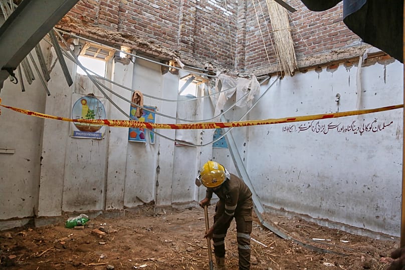 A rescue worker searches through the rubble of a roof collapse at a private school in Peshawar, 15 October, 2026