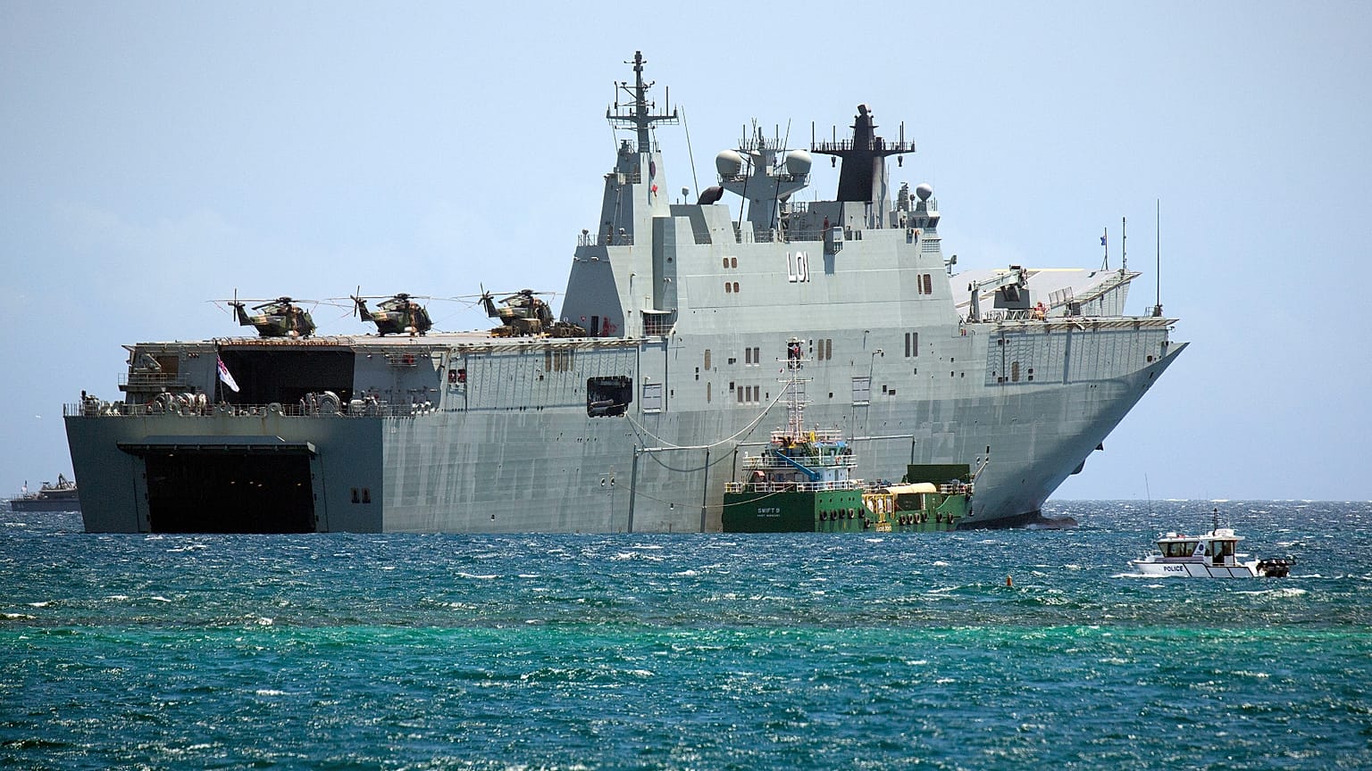 يمر قارب دورية تابع لشرطة بابوا غينيا الجديدة بجوار السفينة البحرية الأسترالية HMAS Adelaide أثناء رسوها قبالة سواحل APEC Haus، المكان الرئيسي لقمة أسبوع القادة الاقتصاديين 