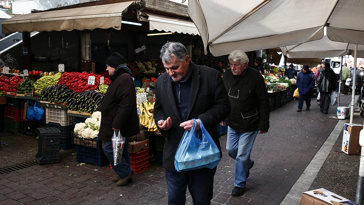 A man checks his money at a central groceries market in Athens, Saturday, Feb. 11, 2017