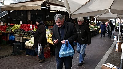 A man checks his money at a central groceries market in Athens, Saturday, Feb. 11, 2017