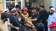 Un miembro de los equipos de rescate lleva en brazos a un niño herido tras sacarlo de entre los escombros del derrumbe del tejado de un colegio privado.