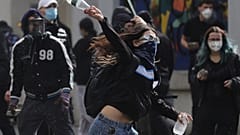 A young protester throws a plastic bottle towards riot police during clashes in Tirana, Albania.