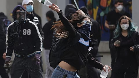 Un joven manifestante lanza una botella de plástico contra la policía antidisturbios durante los enfrentamientos en Tirana, Albania.