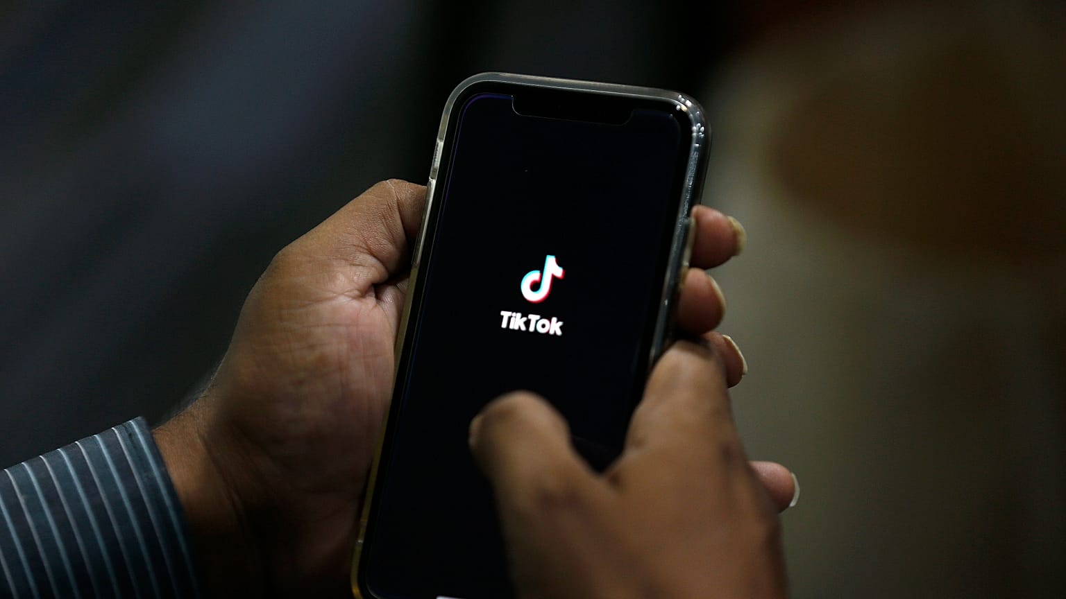Un homme ouvre l'application de réseaux sociaux « TikTok » sur son téléphone portable. (Image d'illustration)