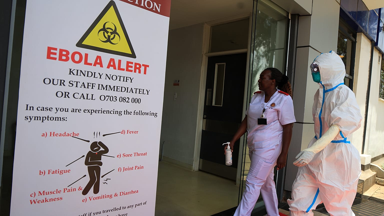 Sanitarios y funcionarios caminan frente a una unidad de aislamiento por ébola del hospital The Nairobi, en Kenia, el miércoles 7 de octubre de 2026.