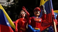 Una partidaria del Gobierno sostiene muñecos que representan a Nicolás Maduro y a Cilia Flores en una marcha para exigir su regreso, en Caracas, ,el 6 de enero de 2026.