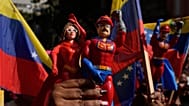 Una partidaria del Gobierno sostiene muñecos que representan a Nicolás Maduro y a Cilia Flores en una marcha para exigir su regreso, en Caracas, ,el 6 de enero de 2026.