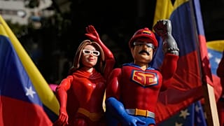 Una partidaria del Gobierno sostiene muñecos que representan a Nicolás Maduro y a Cilia Flores en una marcha para exigir su regreso, en Caracas, ,el 6 de enero de 2026.