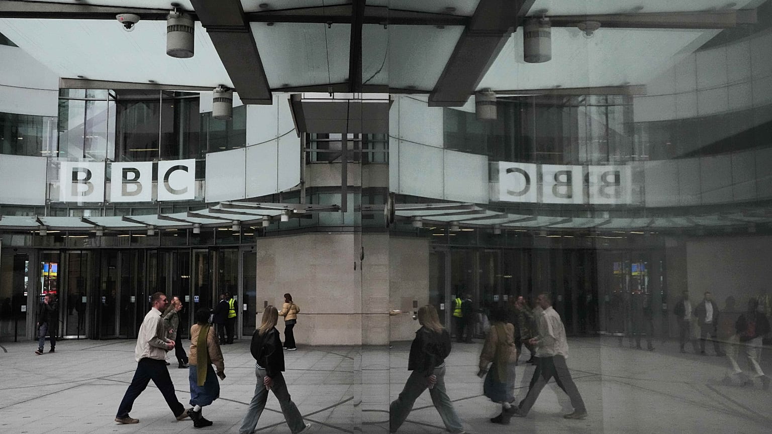 Pedestrians reflected outside BBC Broadcasting House in London, 11 November 2025.