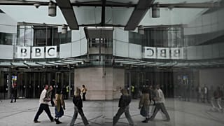 Peões refletem-se no exterior do BBC Broadcasting House, em Londres, a 11 de novembro de 2025
