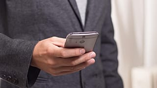 Un hombre sostiene su teléfono móvil 