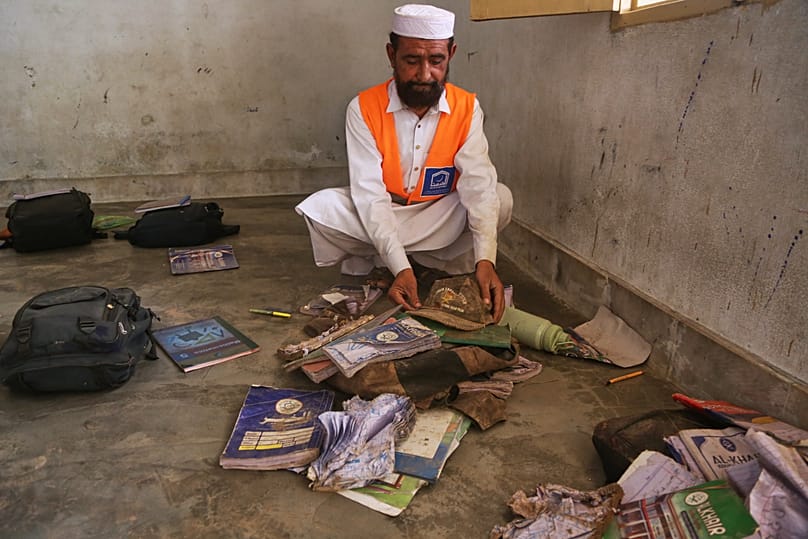 A rescue worker collects books and school bags of victim children at the site of a roof collapse at a private school in Peshawar, 15 October, 2026