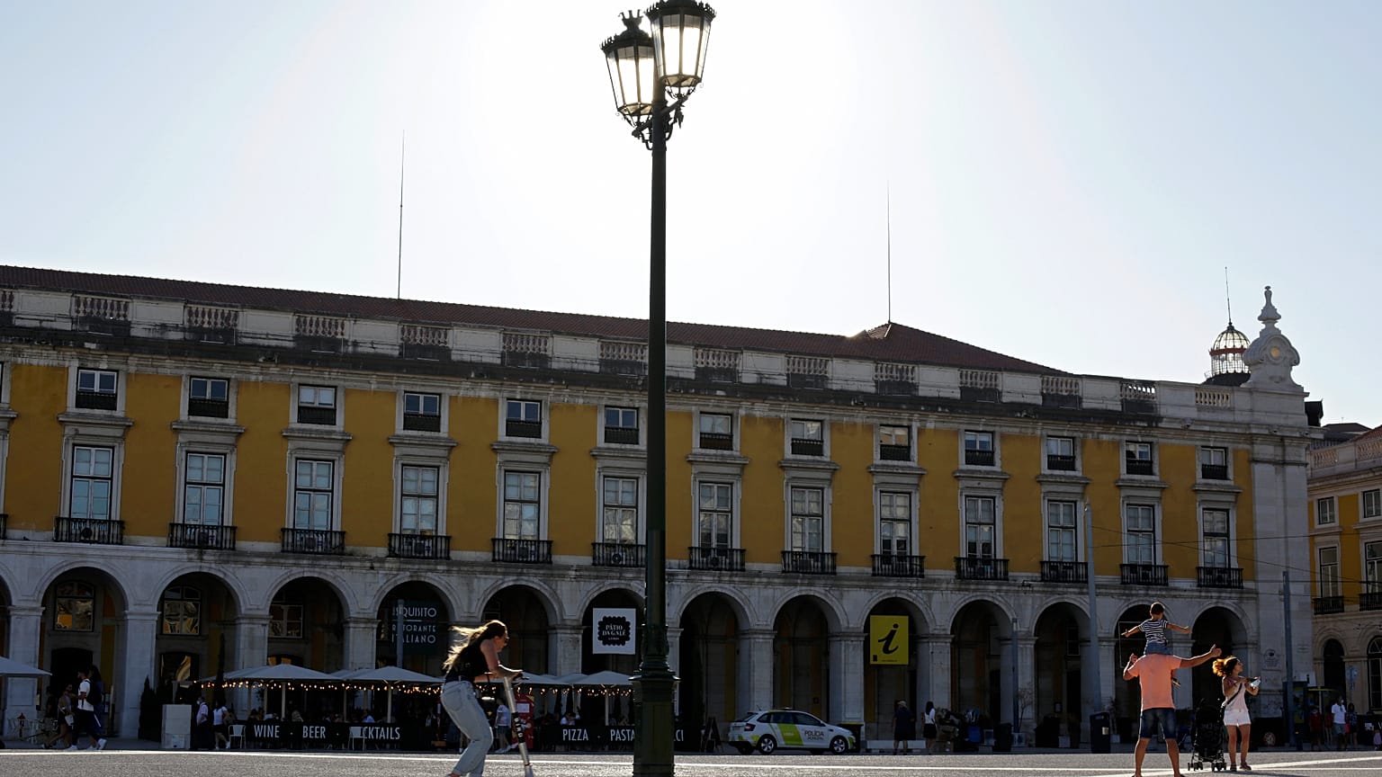 Uma rapariga atravessa a Praça do Comércio, em Lisboa, numa trotineta elétrica, na quinta-feira, 12 de agosto de 2021