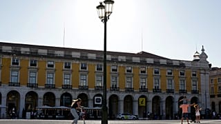 Uma rapariga atravessa a Praça do Comércio, em Lisboa, numa trotineta elétrica, na quinta-feira, 12 de agosto de 2021