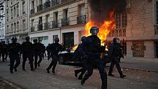 Agenti di polizia corrono verso gli studenti durante una marcia di protesta contro le scuole sottofinanziate a Parigi, il 13 ottobre 2026.