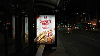 Una imagen de una valla publicitaria de KFC en una marquesina de autobús.
