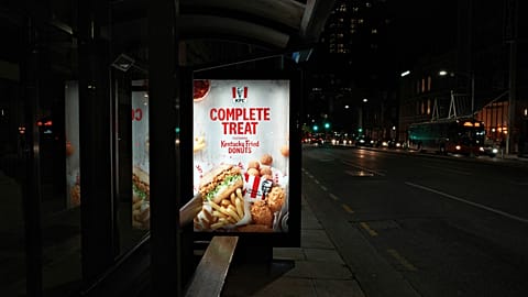 An image of a KFC billboard at a bus shelter.