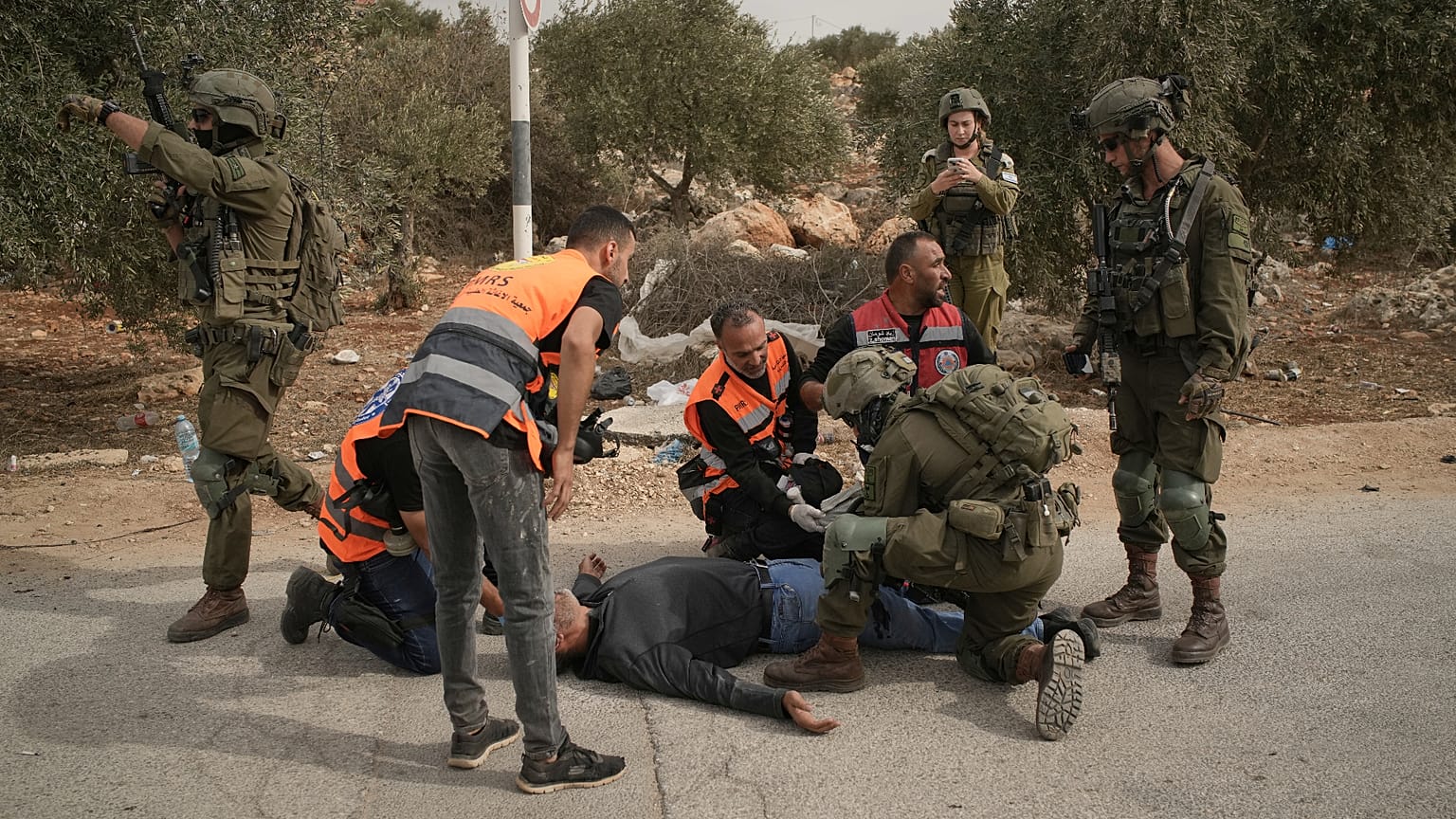طواقم إسعاف فلسطينية وجندي إسرائيلي يسعفون فلسطينياً أصيب برصاص الجيش إثر هجوم مستوطنين على قاطفي زيتون بأبو فلاح بالضفة، 16 أكتوبر 2026.