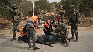 طواقم إسعاف فلسطينية وجندي إسرائيلي يسعفون فلسطينياً أصيب برصاص الجيش إثر هجوم مستوطنين على قاطفي زيتون بأبو فلاح بالضفة، 16 أكتوبر 2026.