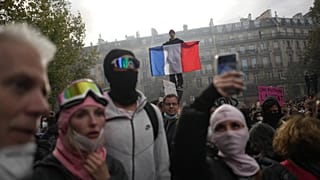 A protester holds a French flag at Republic Square during a demonstration against rising living costs, joining students' grievances, in Paris, Saturday, Oct. 17, 2026