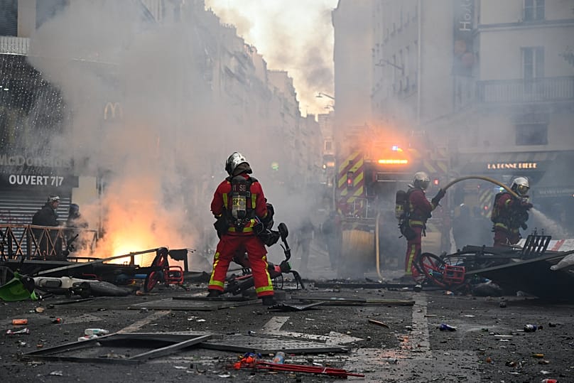 Firefighters extinguish a fire after a demonstration against rising living costs, joining students' grievances, in Paris, Saturday, Oct. 17, 2026. 