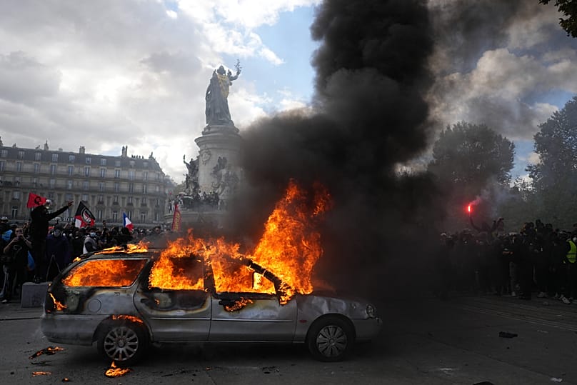 A car burns at Republique square during a protest against rising living costs, joining students' grievances, in Paris, Saturday, Oct. 17, 2026.