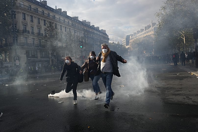 Protesters run to leave the Republique square during a demonstration against rising living costs, joining students' grievances, in Paris, Saturday, Oct. 17, 2026.