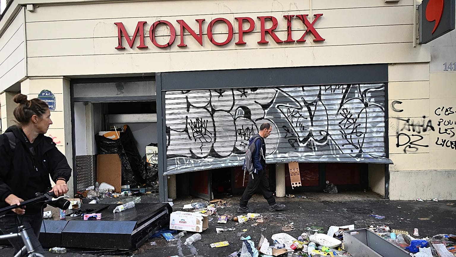 Ein Mann läuft an einem geplünderten Laden vorbei, nach einer Demo gegen steigende Lebenshaltungskosten und in Solidarität mit Studierenden in Paris, 18. Oktober 2026.