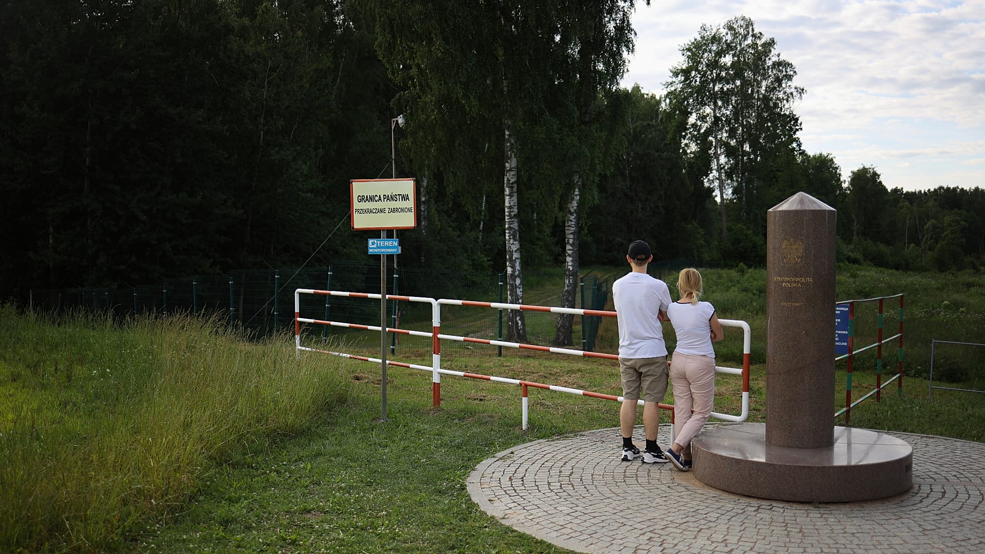 Couple at the point where the borders of Poland, Lithuania and Russia's Kaliningrad region meet, in the town of Zherdziny, Poland.
