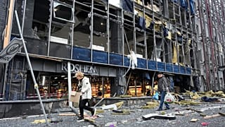 People carry their belongings as they leave their office following Russian air attack in Kyiv, 19 October, 2026