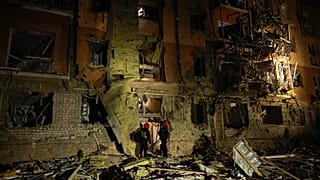 Rescue workers walk in front of a residential building damaged by a Russian airstrike in Zaporizhzhia, 17 October, 2026