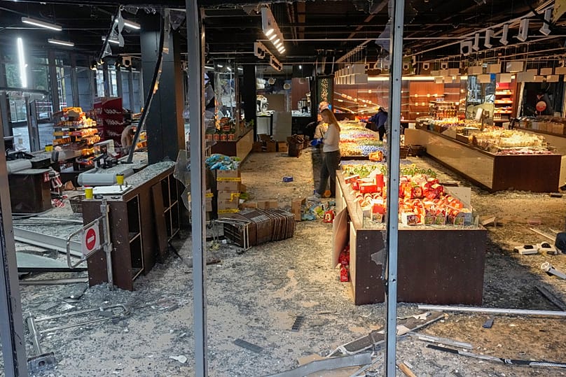 Employees examine the damage at a candy shop after a Russian missile strike in central Kyiv, 19 October, 2026