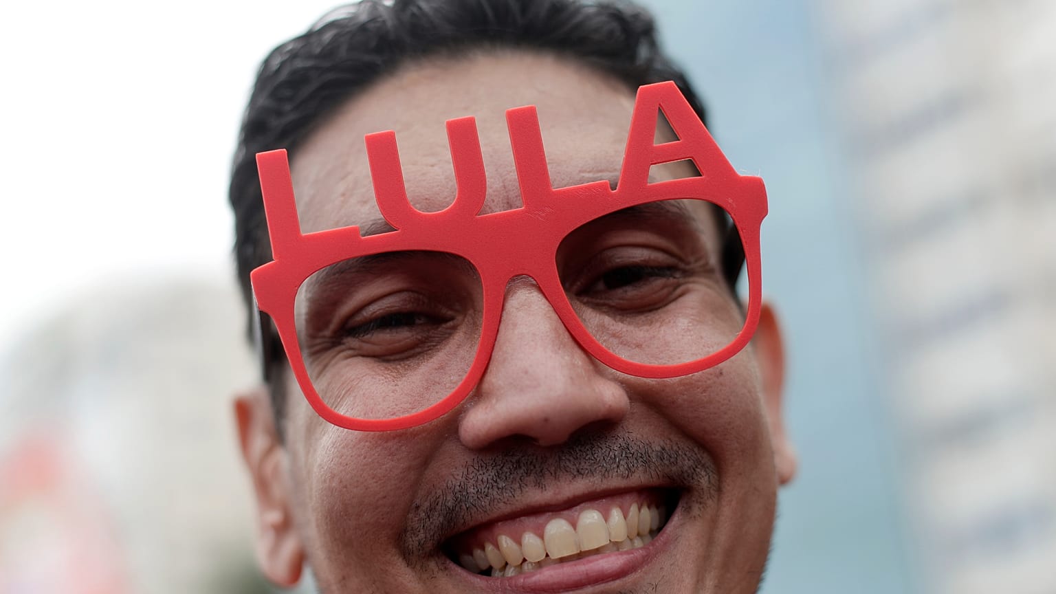 A supporter of Brazilian President Luiz Inacio Lula da Silva wears glasses displaying his name during a campaign rally in Rio de Janeiro, Sunday, Oct. 18, 2026.